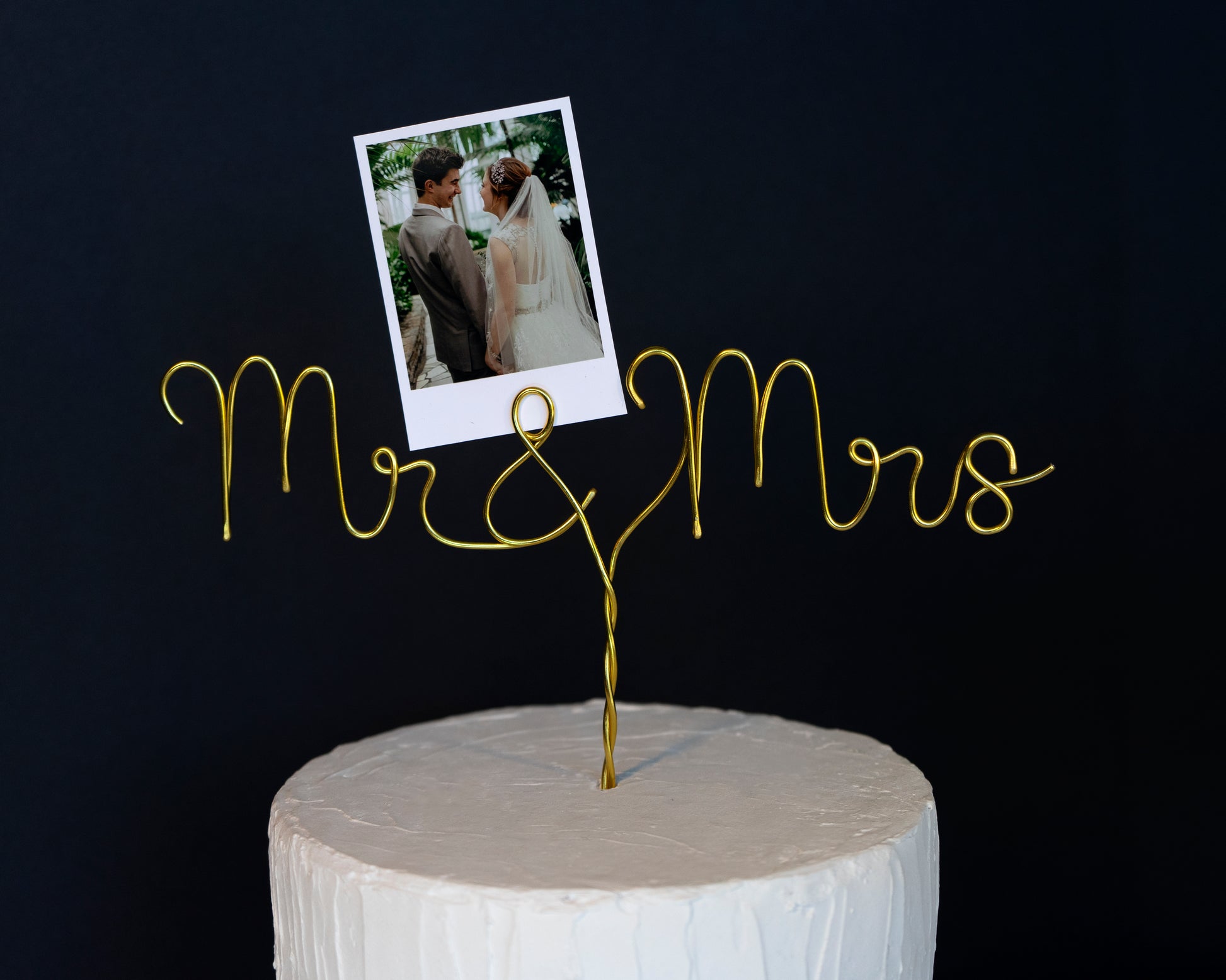 Gold 'Mr & Mrs' cake topper with a photo of a couple on a black background