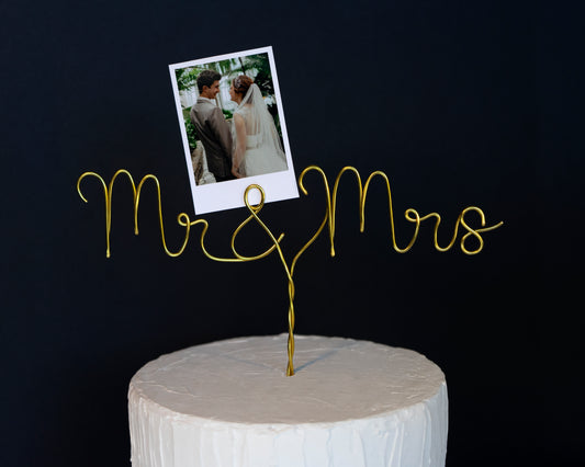 Gold 'Mr & Mrs' cake topper with a photo of a couple on a black background