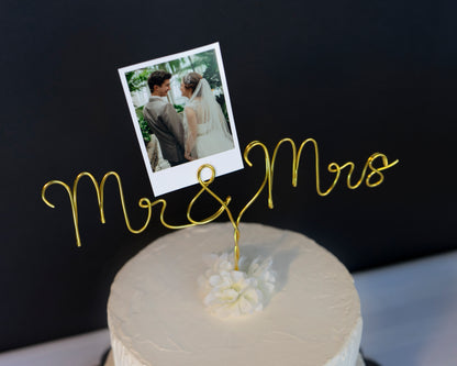 Cake topper with 'Mr & Mrs' and a photo of a couple on a black background
