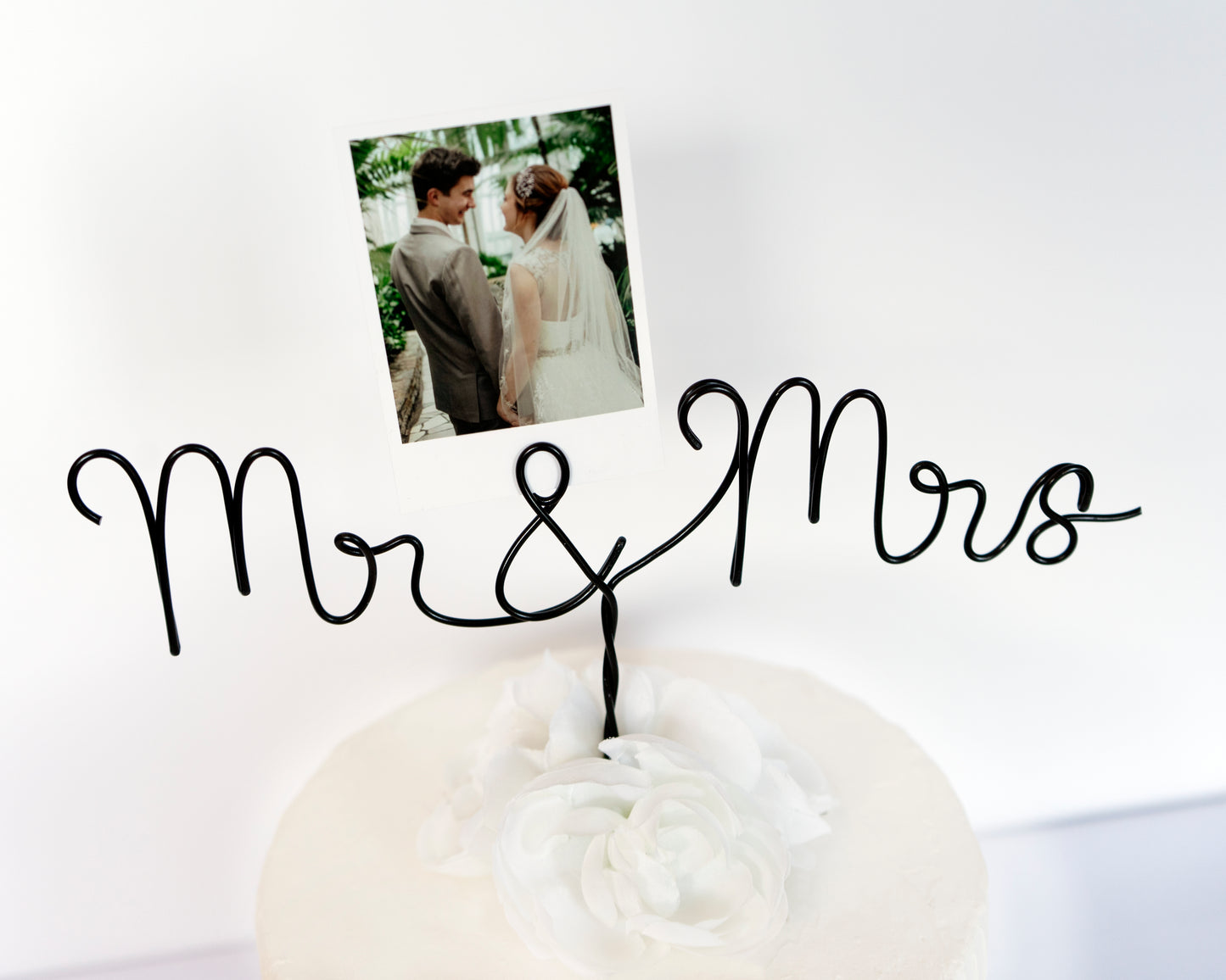 Decorative stand with 'Mr & Mrs' text holding a photo of a couple on a white background